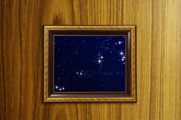 A photo of a wooden picture frame with the night sky setting ins — Stock Photo, Image