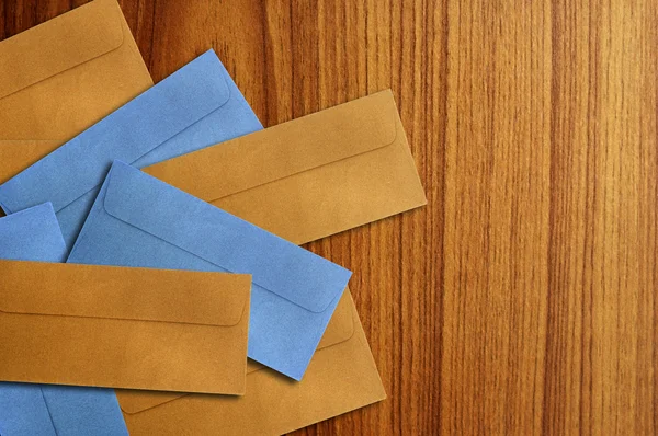 Envelope de cor isolado no fundo de madeira — Fotografia de Stock
