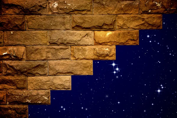 Gece gökyüzünde ışık tuğla duvarın deliğine — Stok fotoğraf