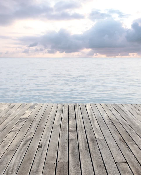 Wooden floor and blue sea with waves and cloudy sky — Stock Photo, Image