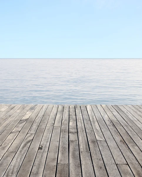 Дерев'яна підлога і блакитне море з хвилями і прозорим блакитним небом — стокове фото