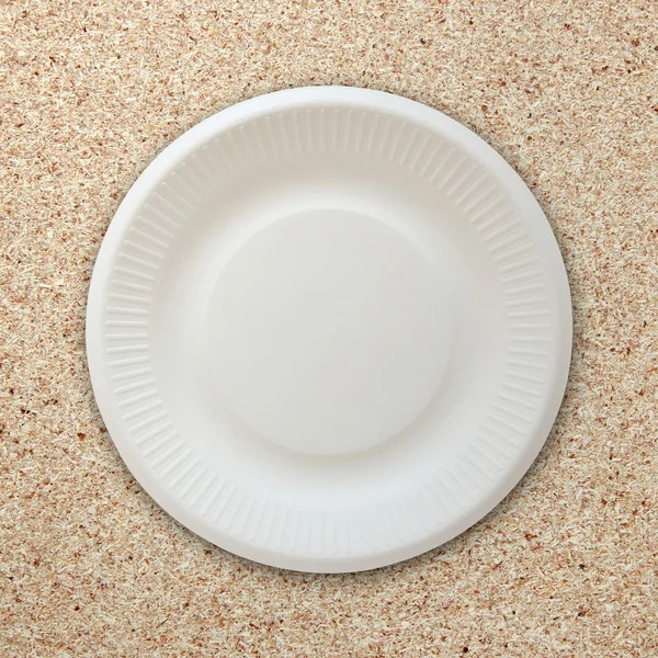 Пустая белая тарелка на фоне пробковой доски — стоковое фото