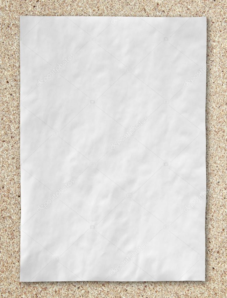 white crumpled paper on cork board background