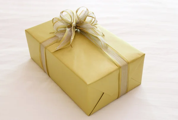 Geschenkbox mit Schleife auf dem Bett — Stockfoto