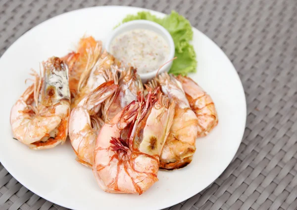 Crevettes grillées avec sauce aux fruits de mer sur assiette blanche — Photo