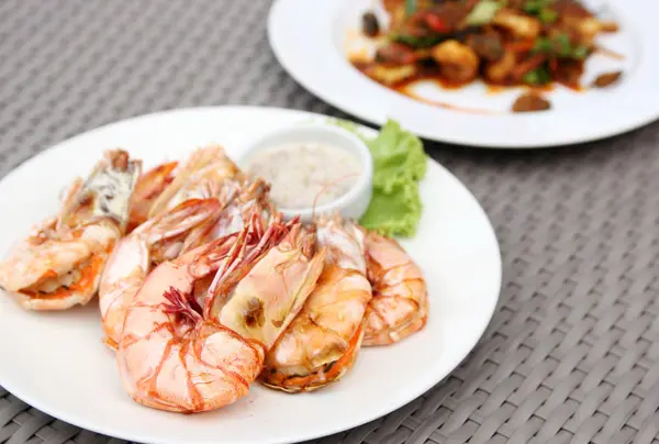 Жареные креветки с соусом из морепродуктов на белой тарелке — стоковое фото