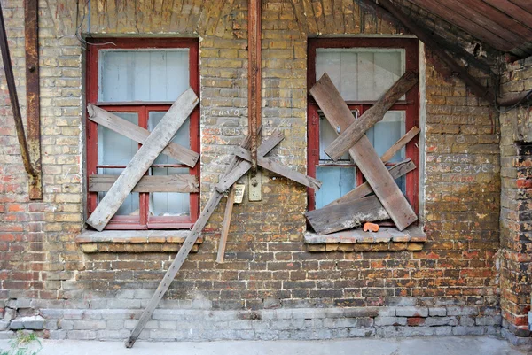 Oude verlaten huis bakstenen muur met overdekte windows — Stockfoto