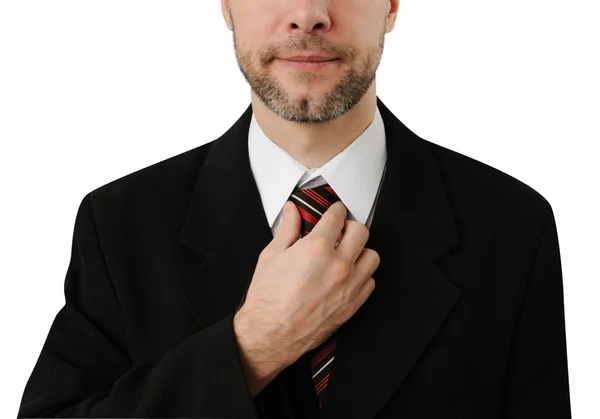 Attractive business man straightens his tie isolated on white — Stock Photo, Image