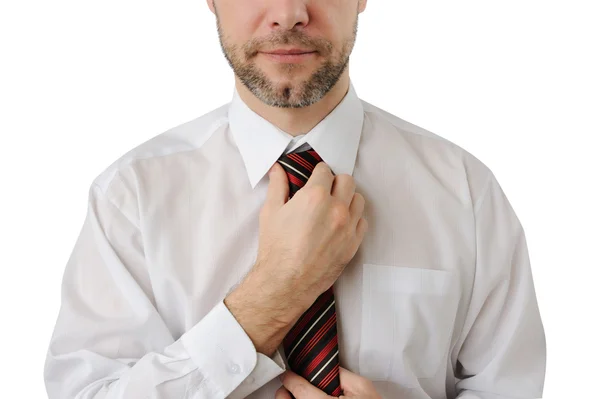 Attractive business man straightens his tie isolated on white — Stock Photo, Image