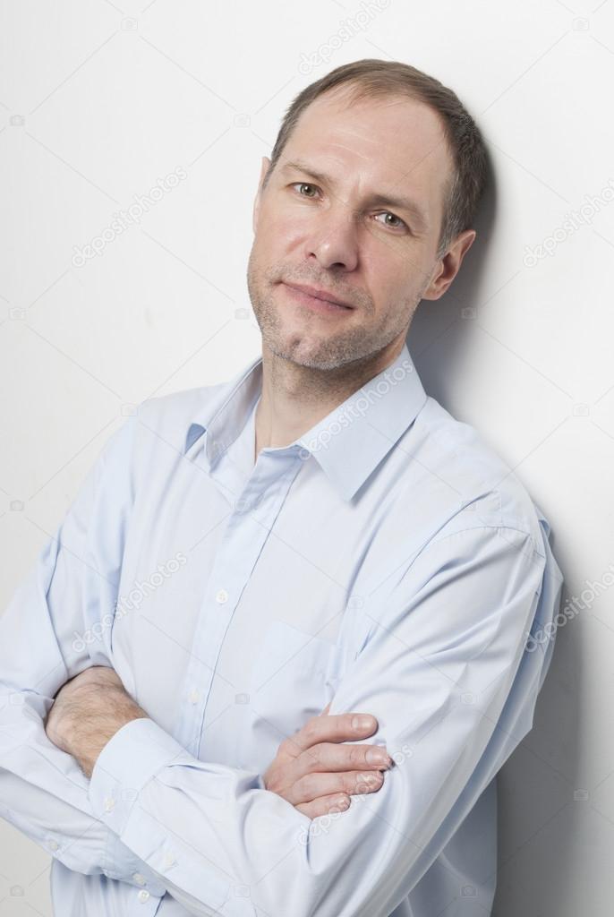 portrait of pensive man in blue against the wall