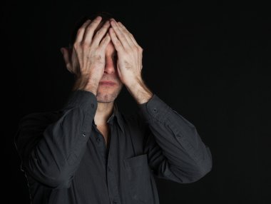 üzgün adam ellerini siyah arka plan üzerine kapalı