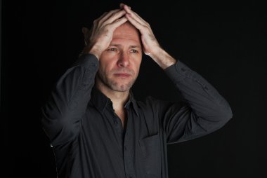 üzgün adam ellerini siyah arka plan üzerine kapalı