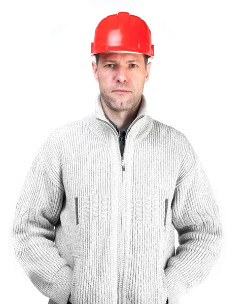 Homem trabalhador sério em um capacete vermelho e casaco — Fotografia de Stock