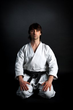 adam bir kimono ile siyah kuşak üzerinde siyah bir adam derin derin düşünür.