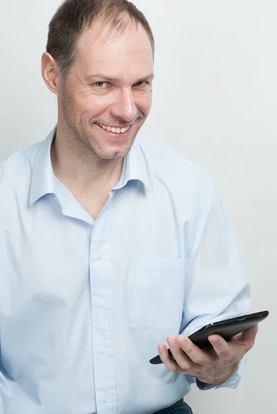 Joven sonriente con tableta sobre fondo blanco — Foto de Stock