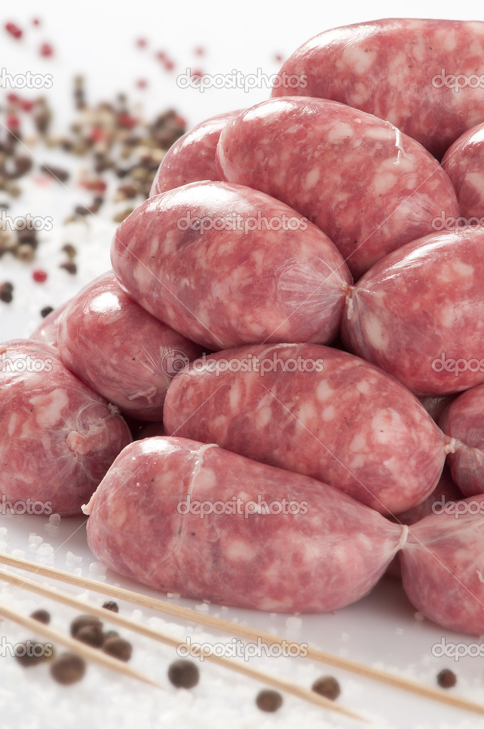 A natural raw sausage on white:toscanelli