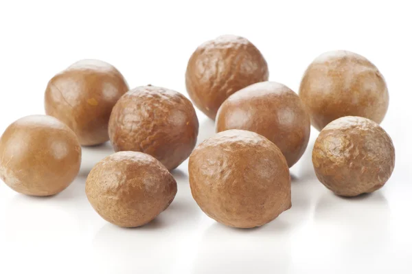 Macadamiapähkinät valkoisella pohjalla — kuvapankkivalokuva
