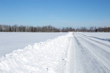 Kış manzarasında yol karla kaplı.