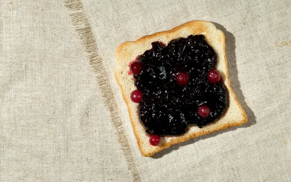 Přípitky s džemem na přírodním textilním pozadí — Stock fotografie