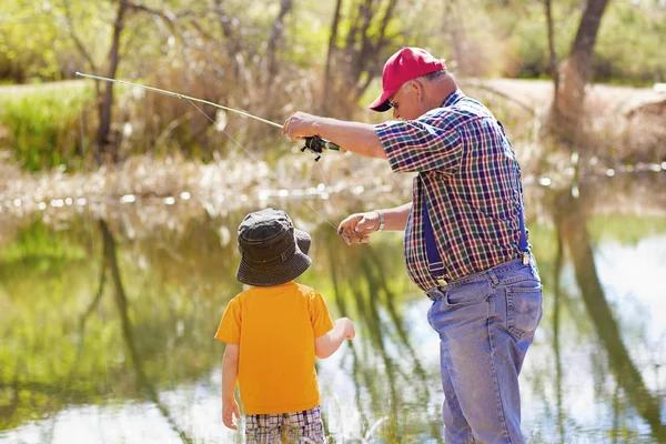 Küçük çocuk ve dedesi bir balık yakalamak — Stok fotoğraf
