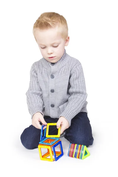 Bonito menino brincando com blocos e formas — Fotografia de Stock