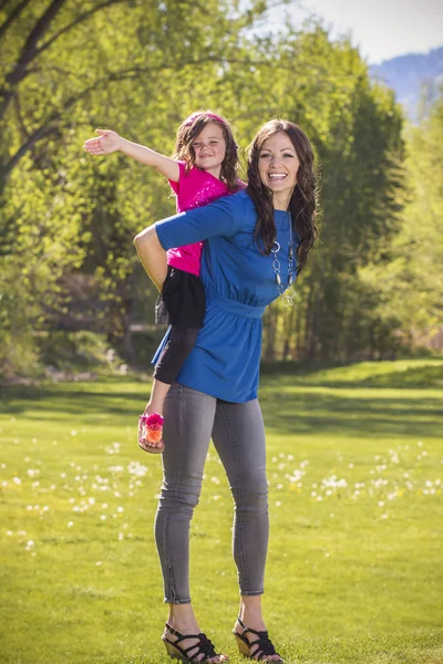 Hermosa familia joven jugando al aire libre juntos —  Fotos de Stock