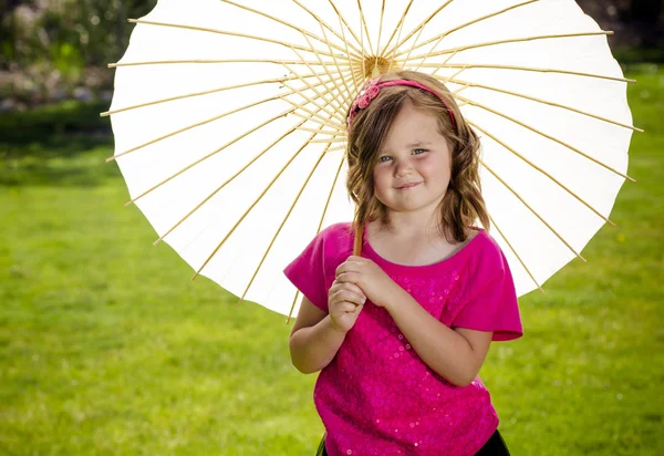 Cute little girl holding a parasol outdoors — Stock Photo, Image