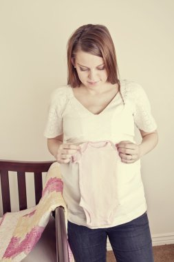 Annesi holding yeni bebek giysileri bekliyor