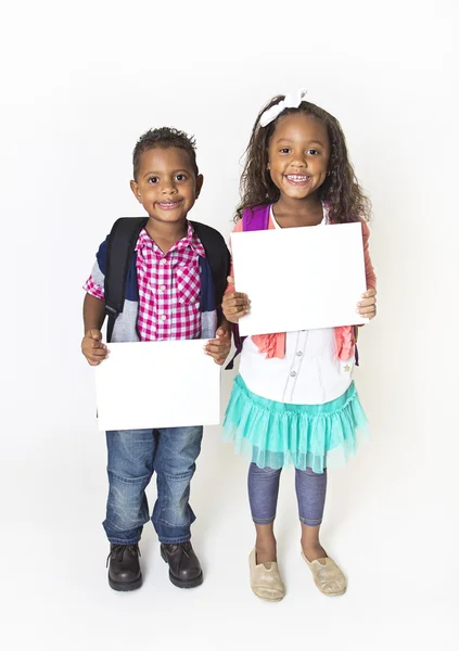 Zwei süße Kinder halten ein leeres Schild hoch — Stockfoto