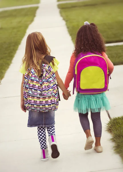 Маленькие девочки идут в школу вместе — стоковое фото