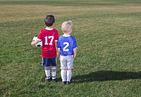 Twee jonge voetballers uit verschillende teams op een grasveld klaar om te spelen — Stockfoto