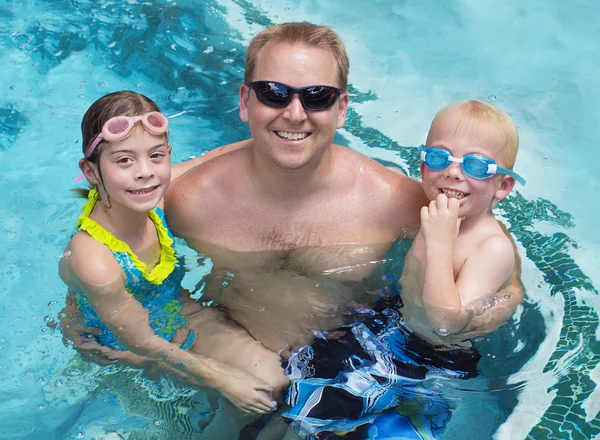 Familie samenspelen in het zwembad — Stockfoto