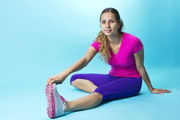 Hispanic fitness vrouw die zich uitstrekt — Stockfoto