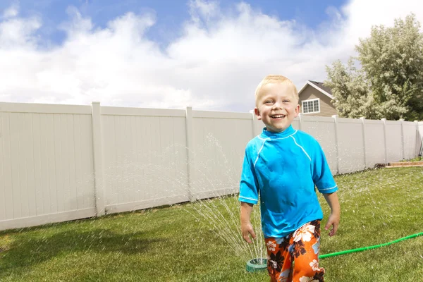 Sprinkler oynayan küçük çocuk — Stok fotoğraf