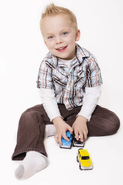 Симпатичный мальчик, играющий со своими игрушками — стоковое фото