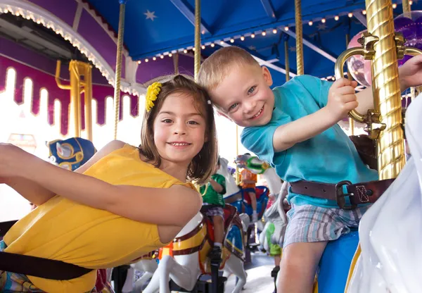 Kids having fun on a carnival carousel — Stock Photo, Image