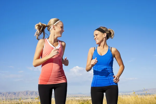 Dos hermosas mujeres corriendo juntas — Foto de Stock