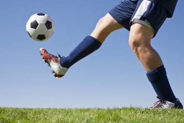 sahada futbol topu tekmeleme atlet