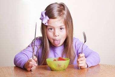 Cute little girl not wanting to eat healthy food clipart