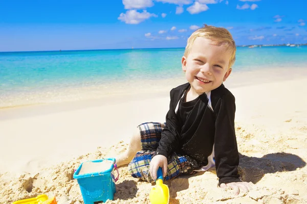 Mały chłopiec bawi się w piasku na plaży — Zdjęcie stockowe