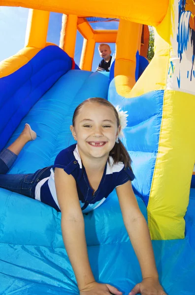 Crianças que jogam em uma casa inflável do salto da corrediça — Fotografia de Stock