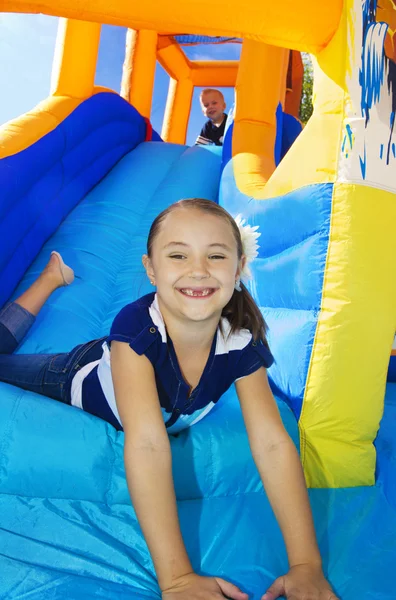 Kinderen spelen op een opblaasbare glijbaan stuiteren huis — Stockfoto