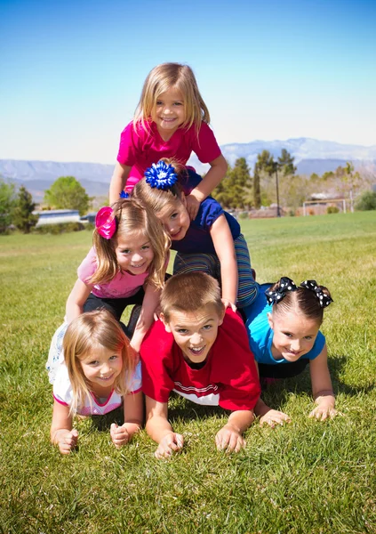 Niedliche Kinder bauen eine menschliche Pyramide im Freien — Stockfoto