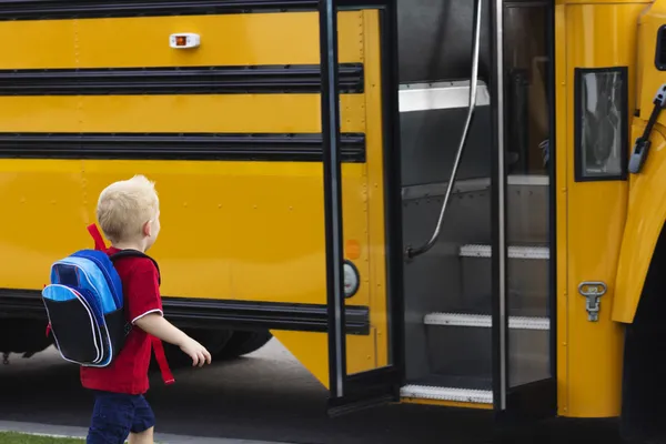 Un enfant monte dans un autobus scolaire — Photo