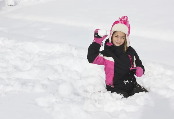 Lille pige har en snebold kamp - Stock-foto