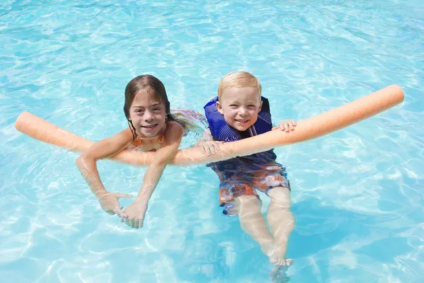 Kinder spielen gemeinsam im Schwimmbad — Stockfoto