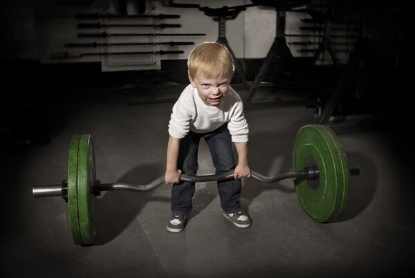 Determined Young Boy trying to lift Heavy weights
