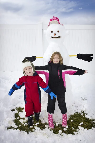 2 人の子供、雪だるまの構築 — ストック写真