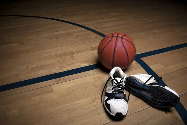 Basketbalveld met bal en schoenen — Stockfoto