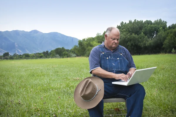 Oude boer tot aanpassing aan de leeftijd van de computer — Stockfoto